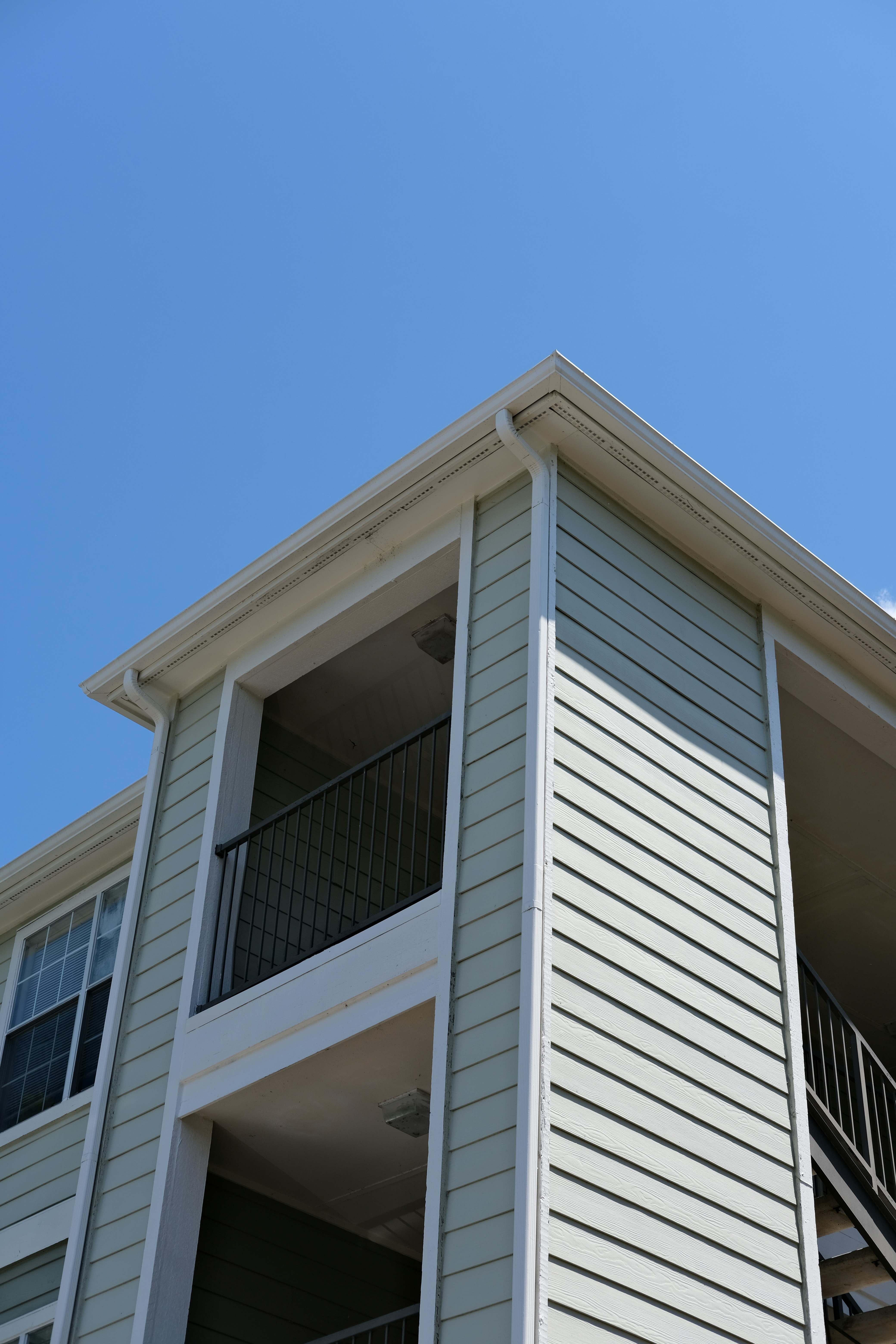 a tall white building with balconies and a balcony
