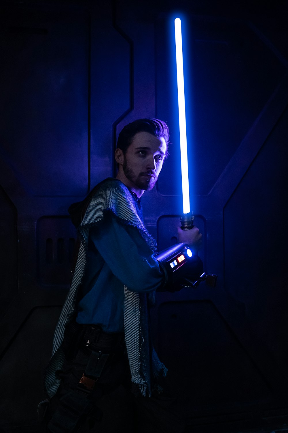 a man holding a light saber in a dark room