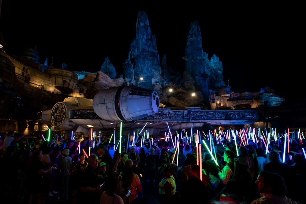 a crowd of people standing around a building with lights