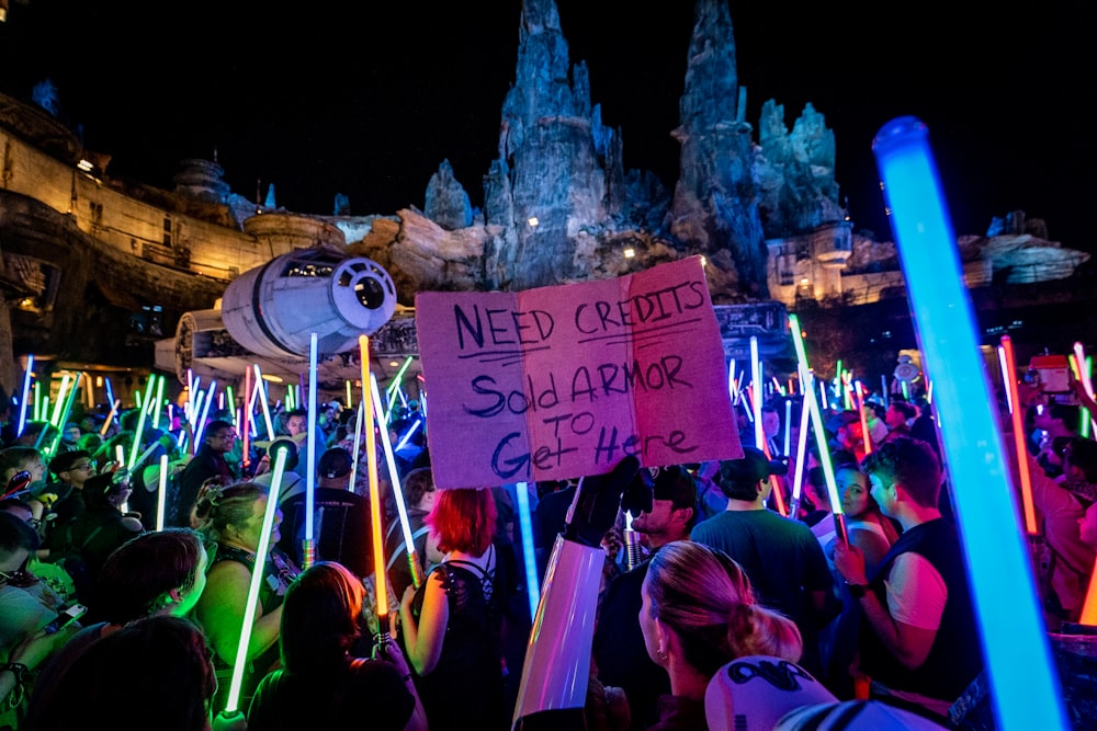 a crowd of people holding up signs and lights