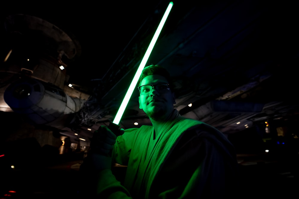 a man holding a light saber in a dark room