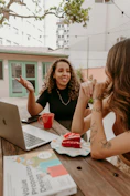 Two women sitting at a table with a laptop