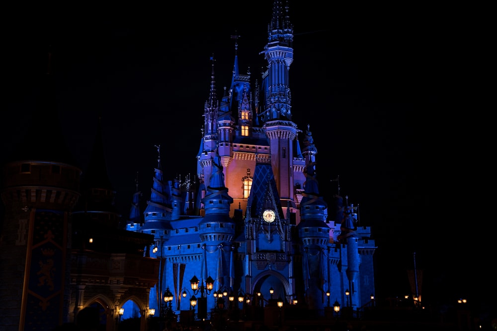 a castle lit up at night with a clock