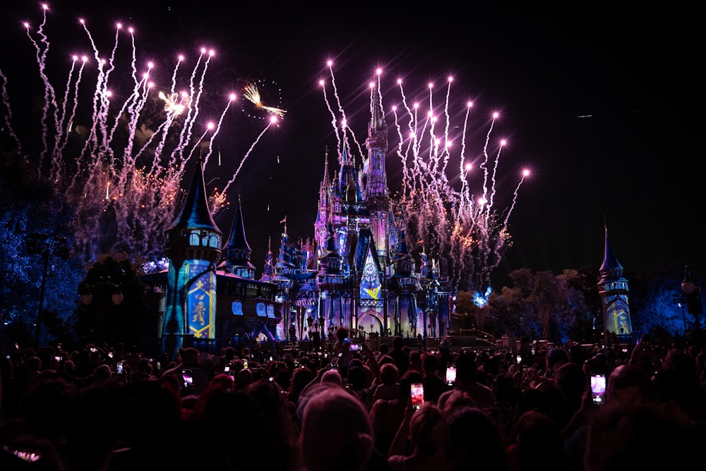 a crowd of people standing around a castle at night