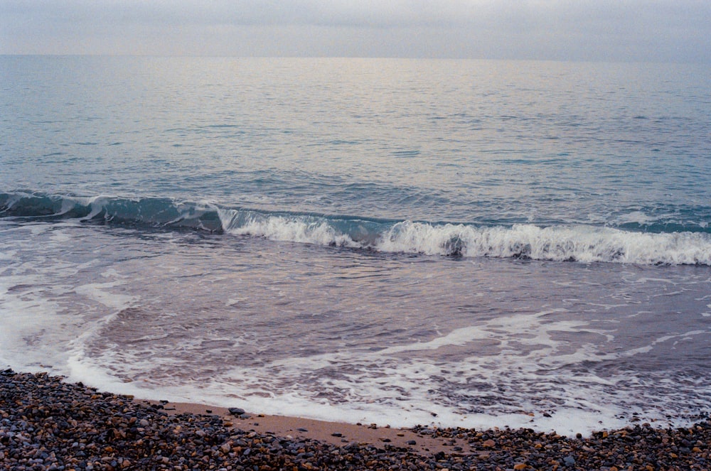 a beach with a wave coming in to shore