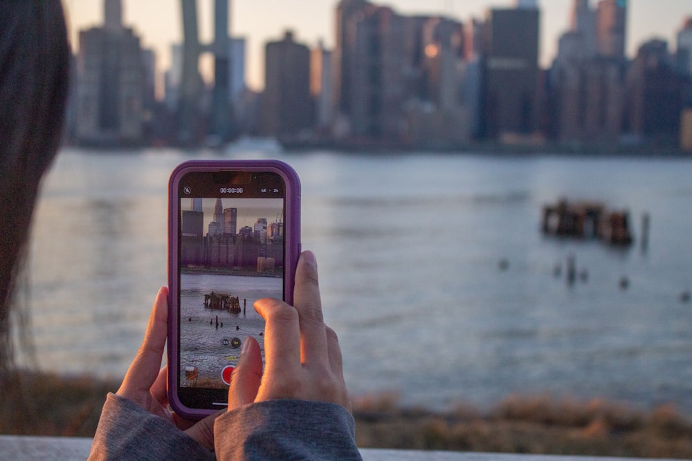 a person taking a picture of a city with a cell phone