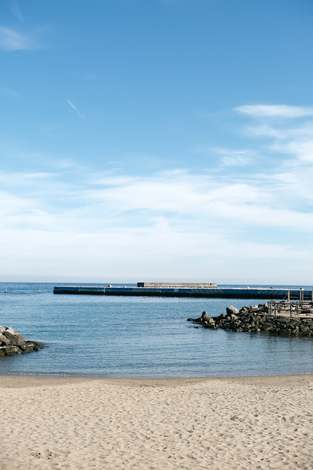 a sandy beach with a pier in the distance