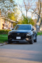 A sleek SUV parked outside a suburban home, ready for a long trip.