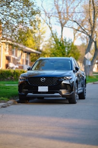 Shiny black SUV parked in front of a modern house