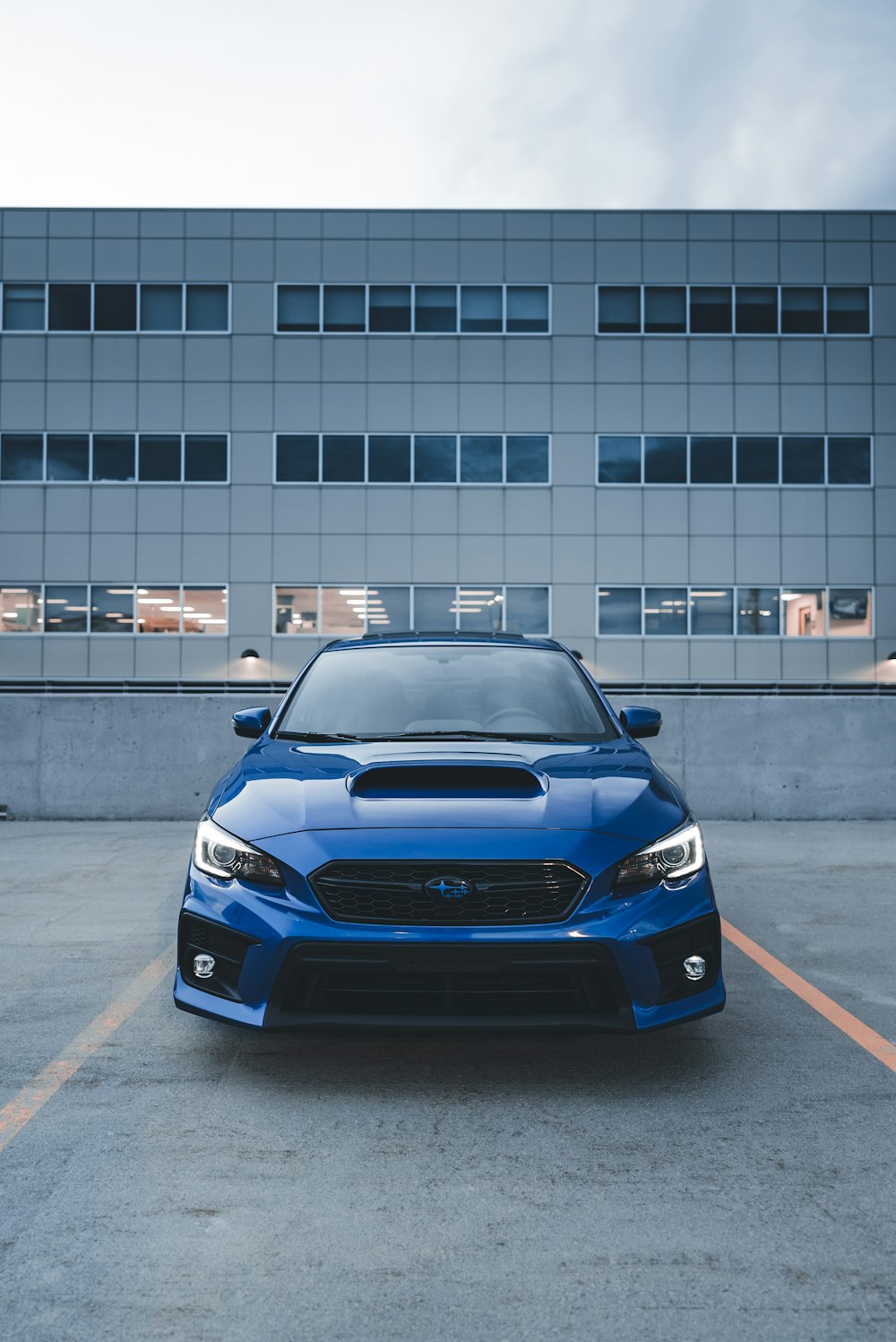 a blue subaru is parked in a parking lot