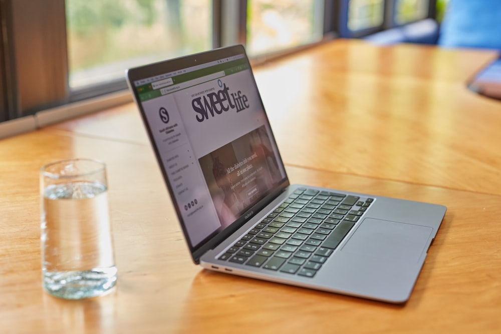 a laptop computer sitting on top of a wooden table