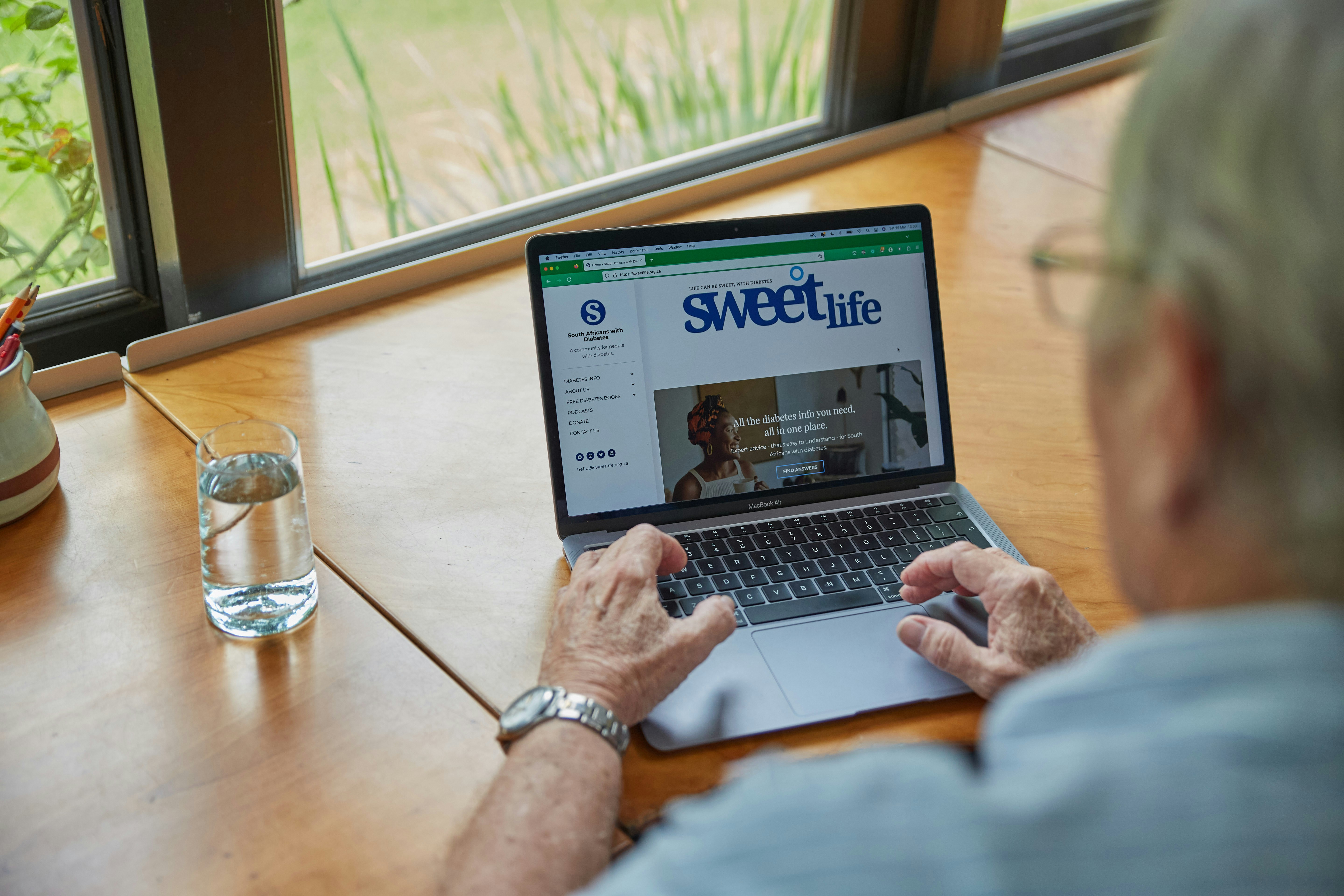 An old South African man with diabetes working on his laptop