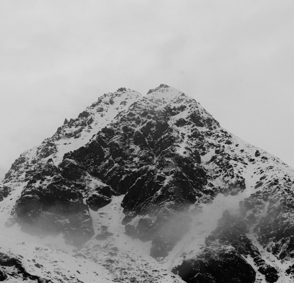 a mountain covered in snow with a sky background