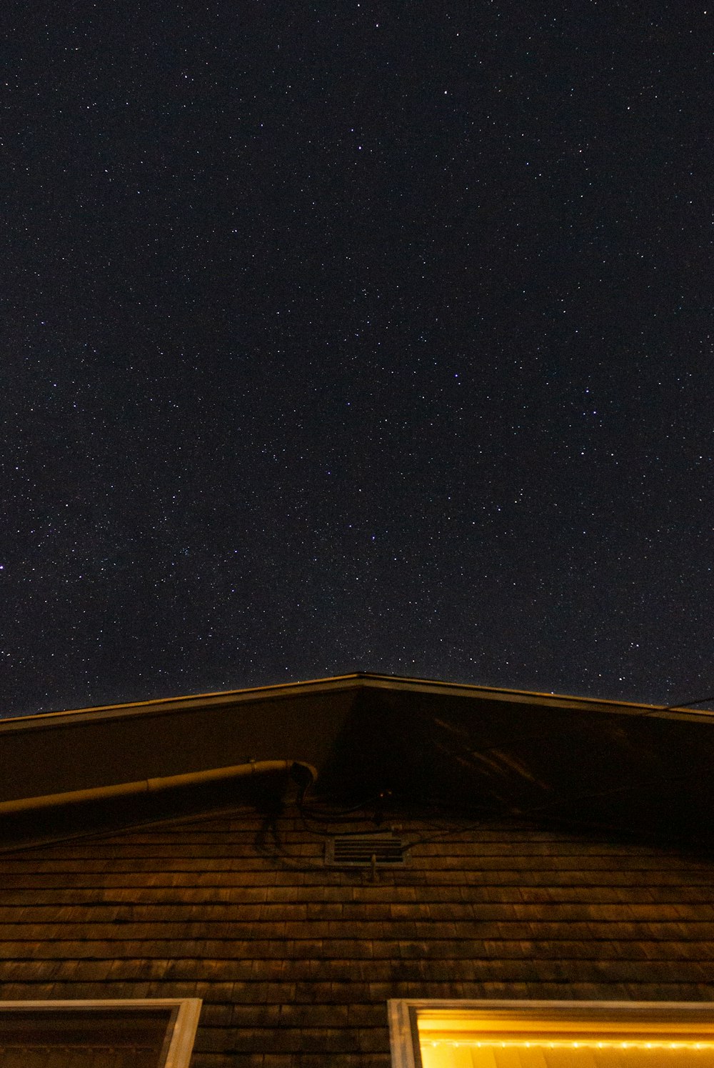 a night sky with stars above a brick building