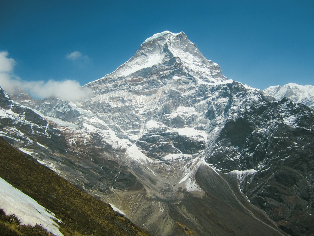 a large snow covered mountain with a blue sky in the background