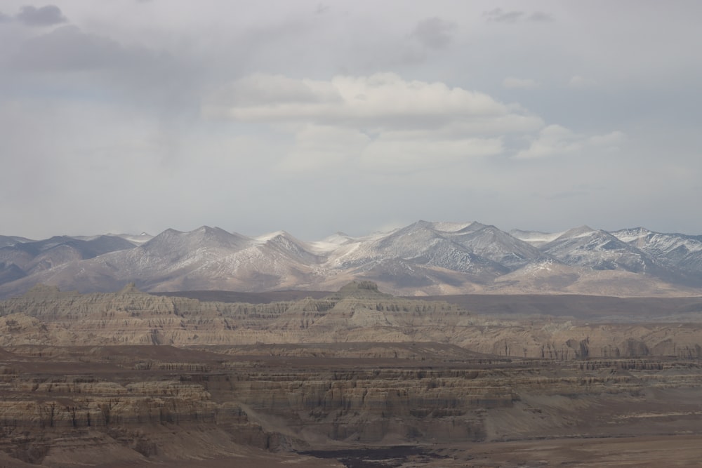 a mountain range with snow capped mountains in the distance