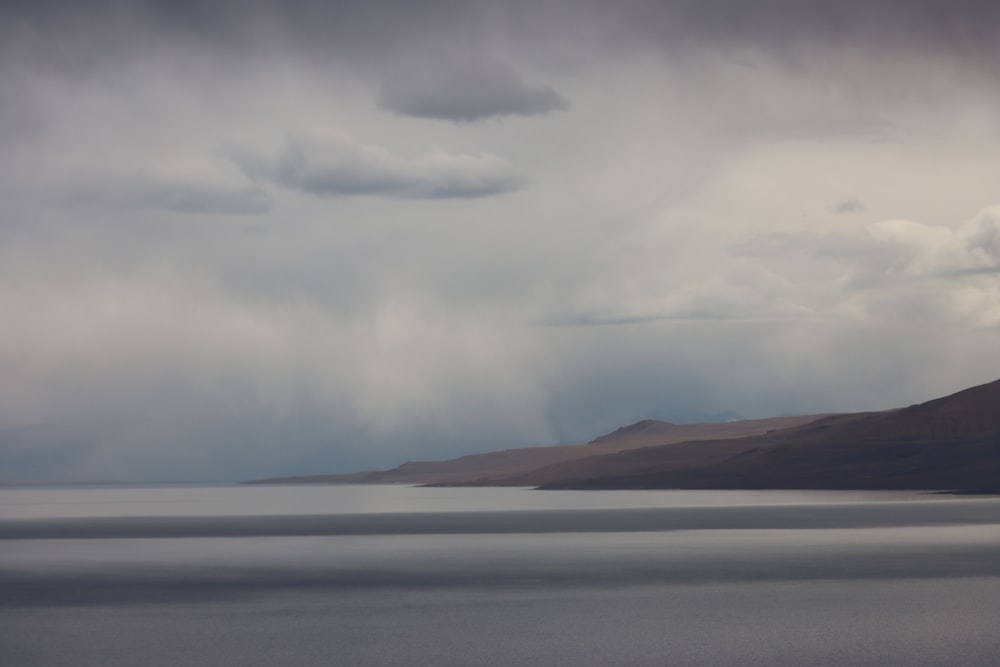 a large body of water under a cloudy sky