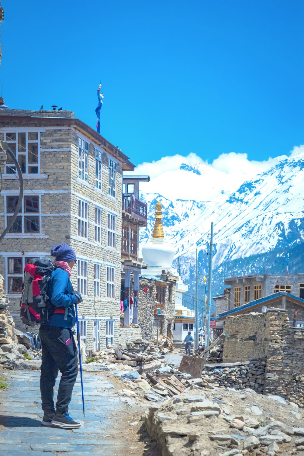 a man with a backpack is walking down a street