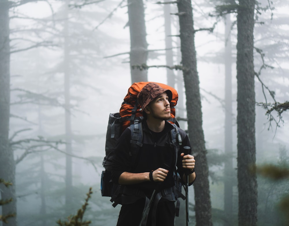 a man with a backpack in a foggy forest