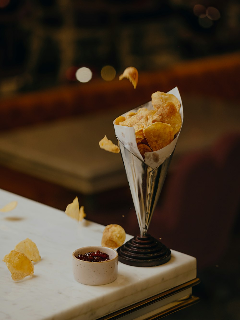 a table topped with a vase filled with chips