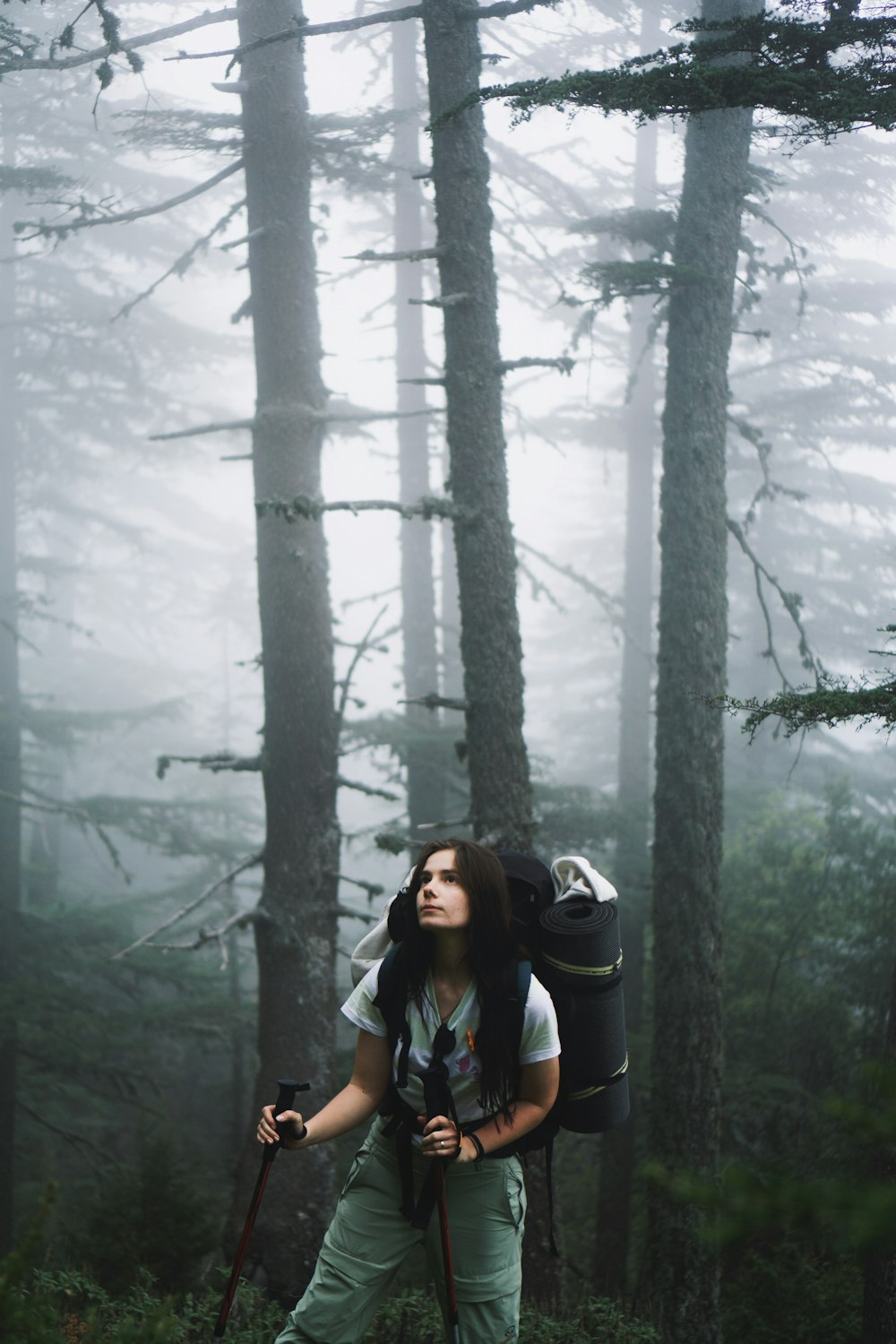 a woman with a backpack is hiking through the woods