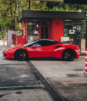 a red sports car parked in front of a gas station