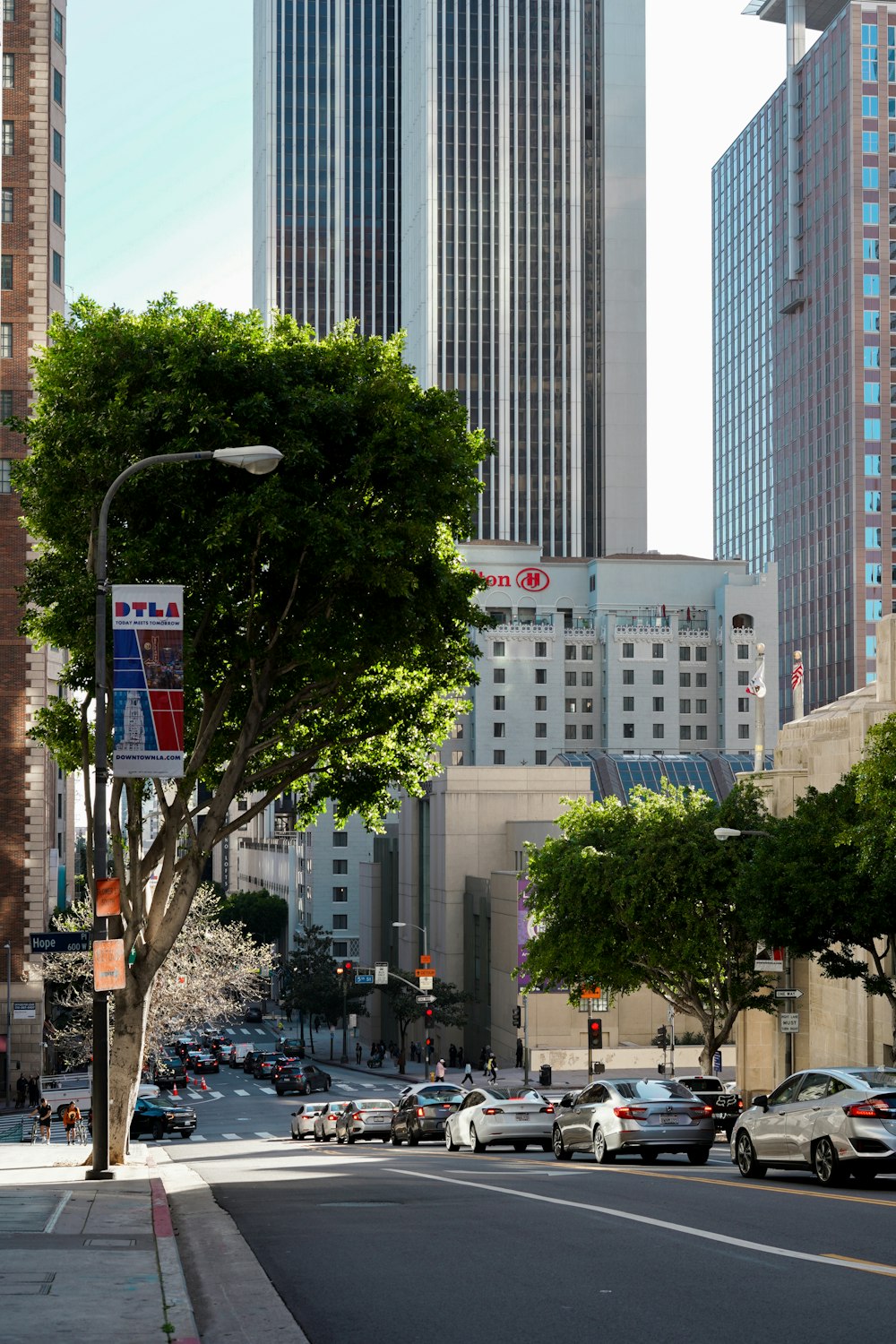 a city street filled with lots of traffic next to tall buildings