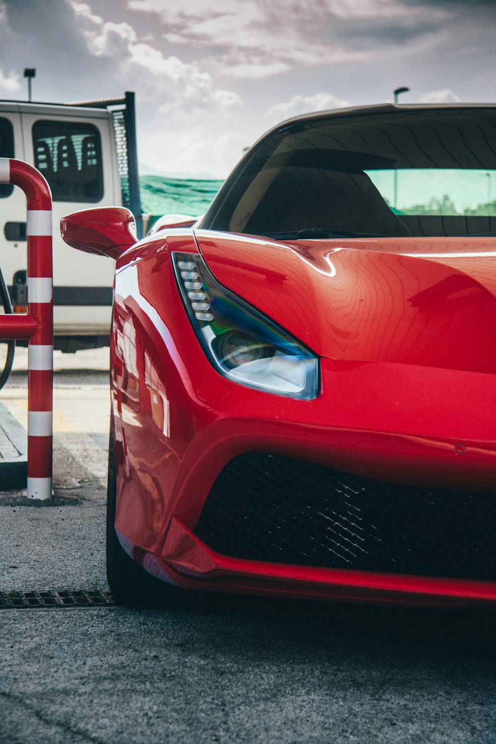 um carro esportivo vermelho estacionado em um posto de gasolina