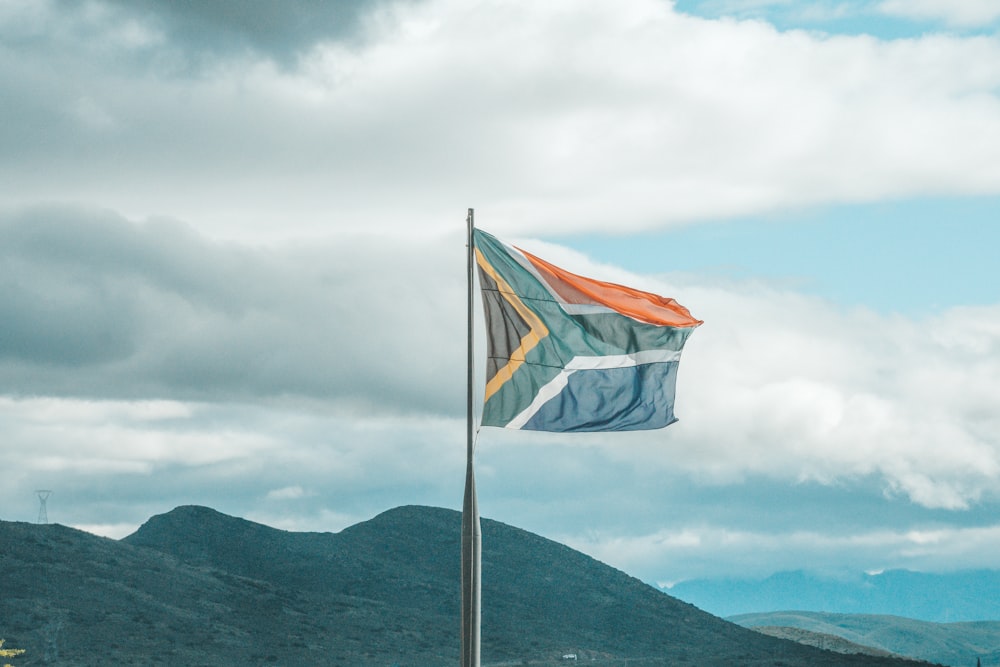 a flag on a pole with mountains in the background