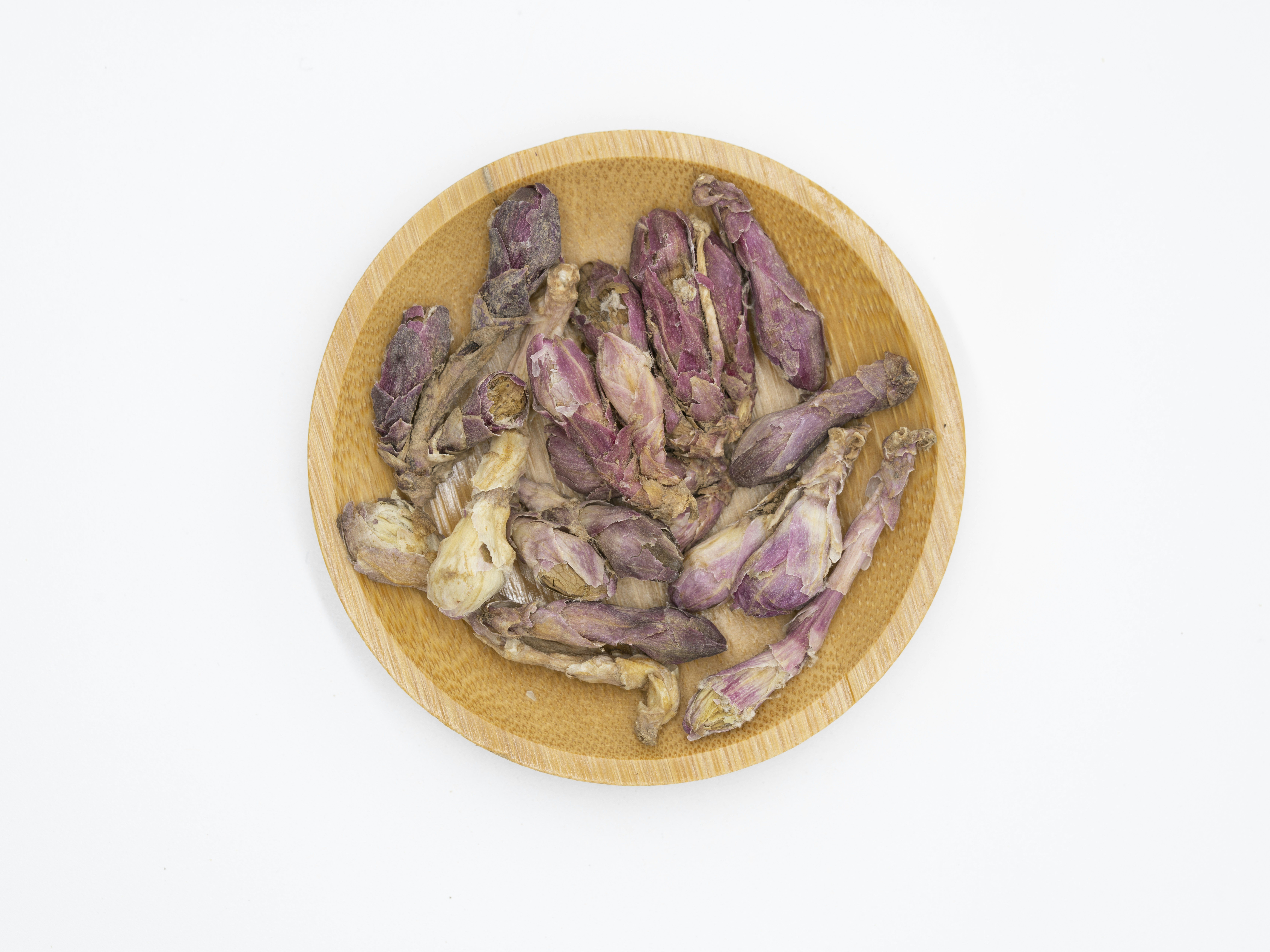 Dried traditional medicinal herbs arranged in a wooden bowl
