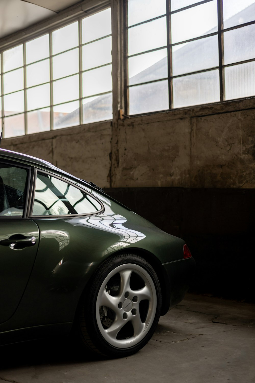 a green sports car parked in a garage