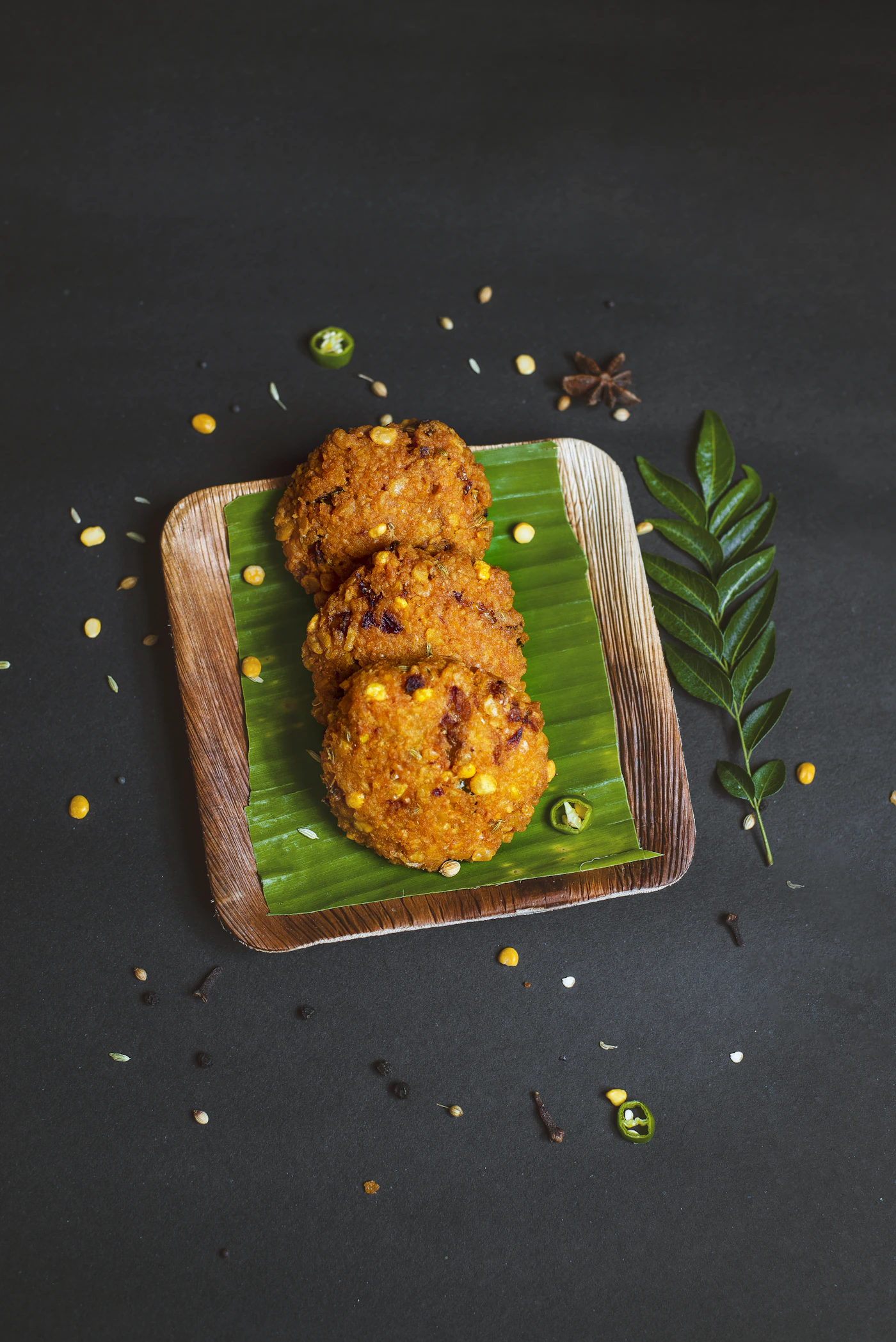 Crisp vadas on a banana leaf with curry leaves