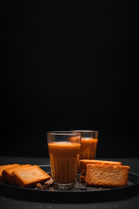 a glass of orange juice and some toast on a plate