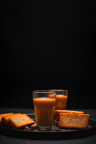 a glass of orange juice and some toast on a plate
