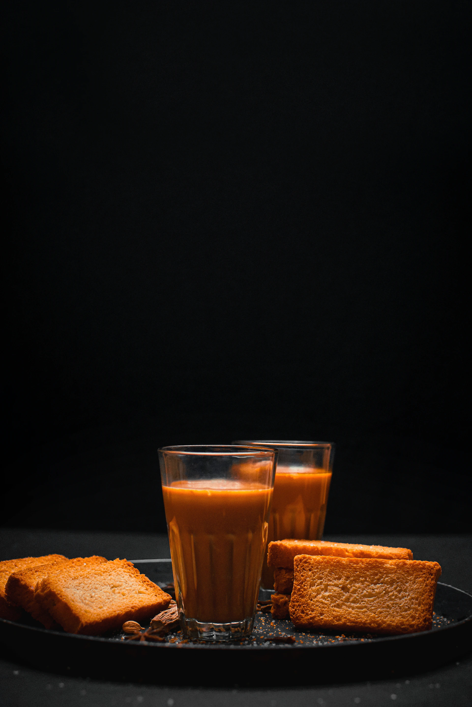 a glass of orange juice and some toast on a plate