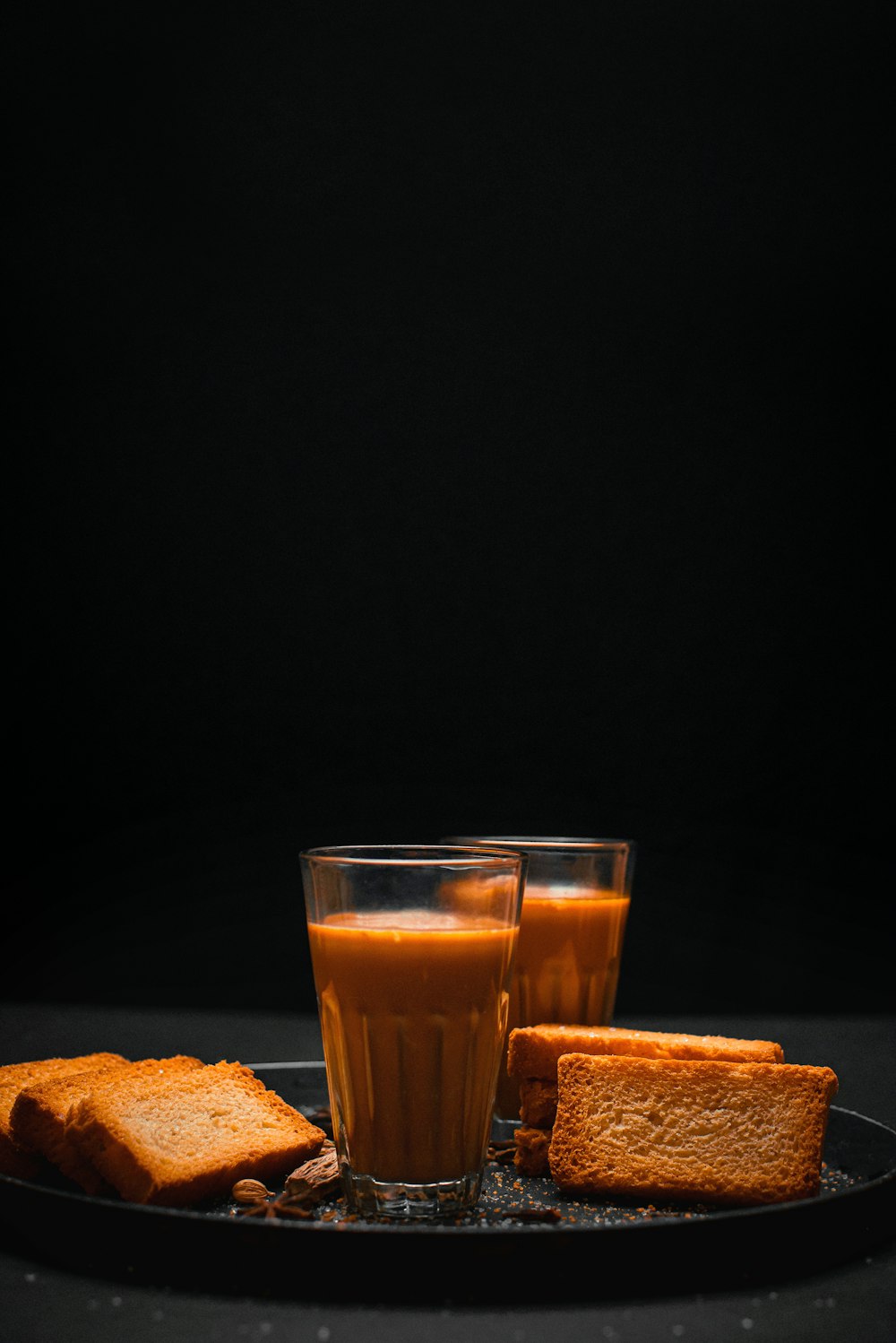 a glass of orange juice and some toast on a plate