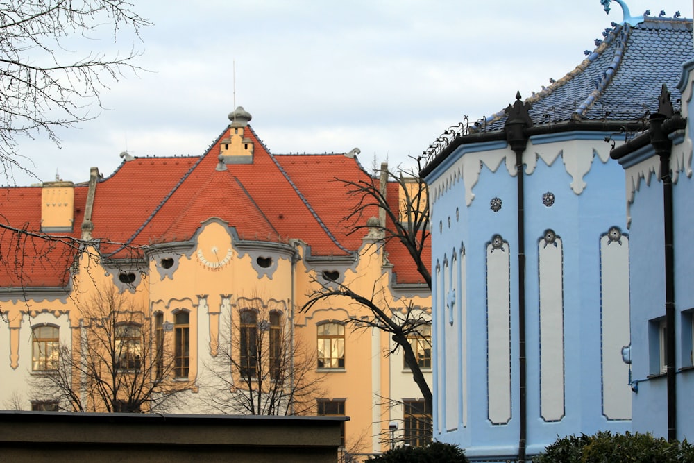 a blue and yellow building with a red roof