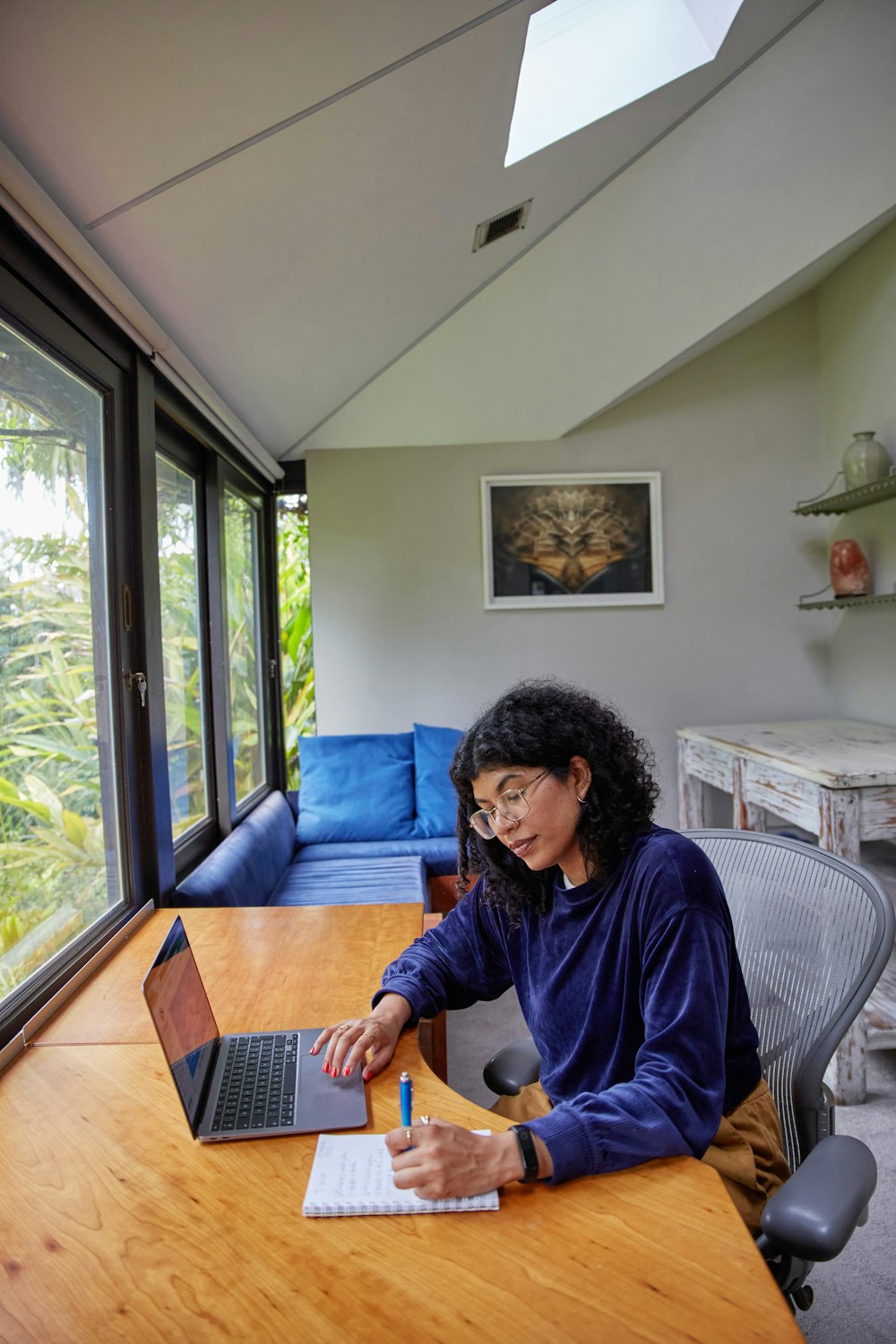 a woman sitting at a table using a laptop computer