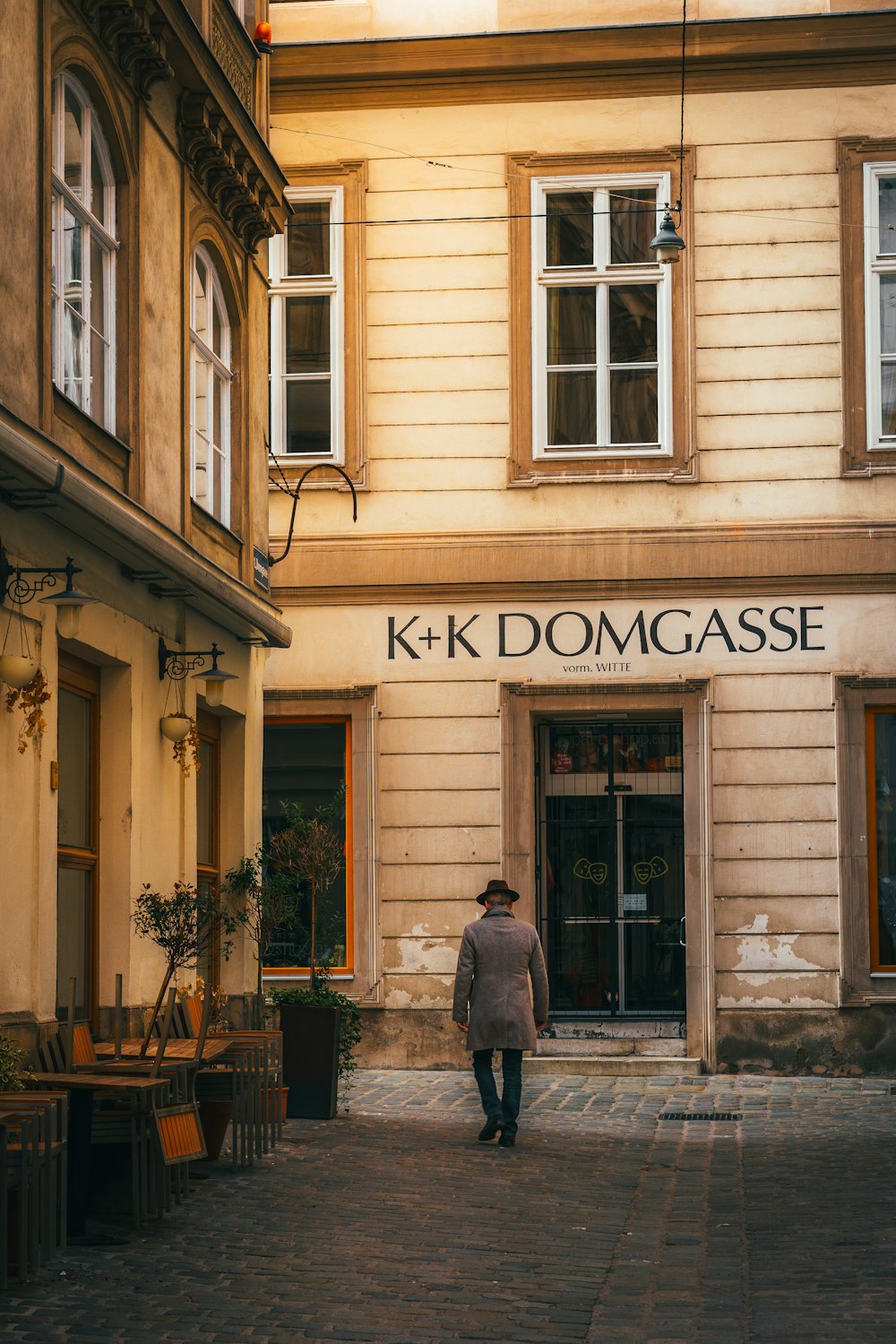 a man walking down a street in front of a building