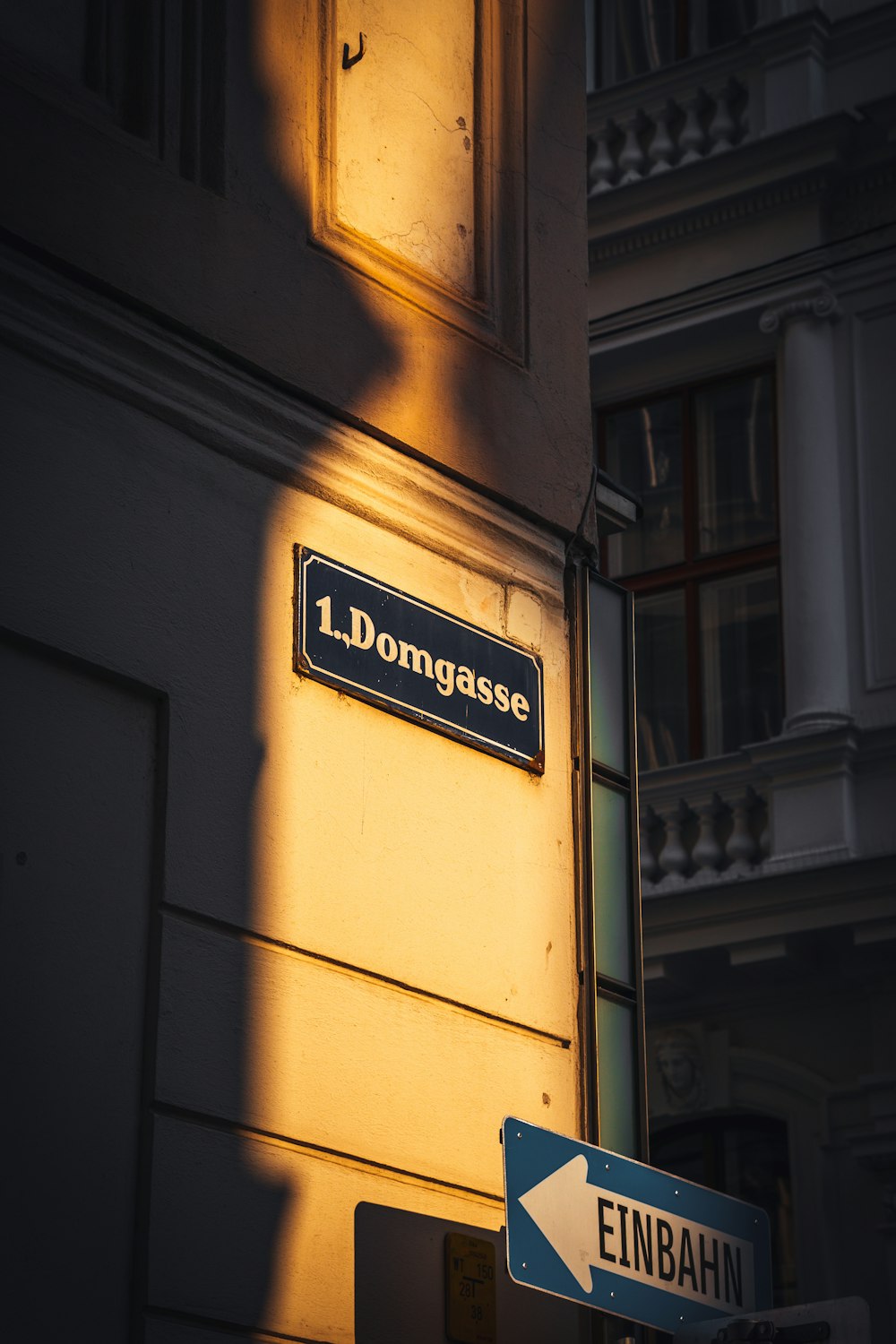 a street sign next to a building with a light shining on it