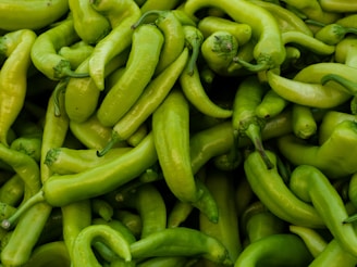 a pile of green peppers sitting next to each other