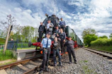 Young railway employees training together on a vibrant football field under clear skies.