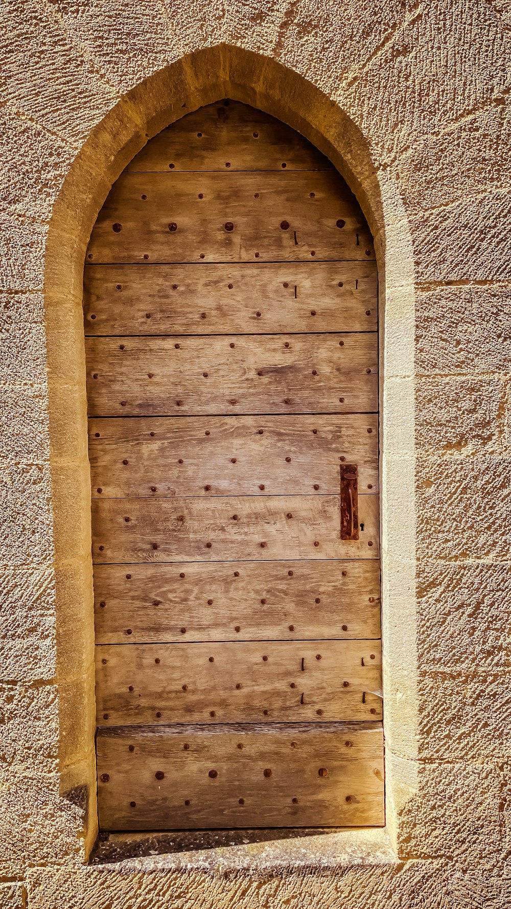a wooden door with a stone arch above it