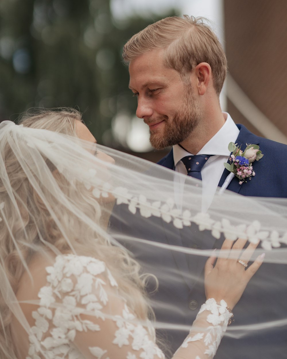 a man and a woman standing next to each other under a veil