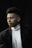 a man in a black suit and white turtle neck shirt