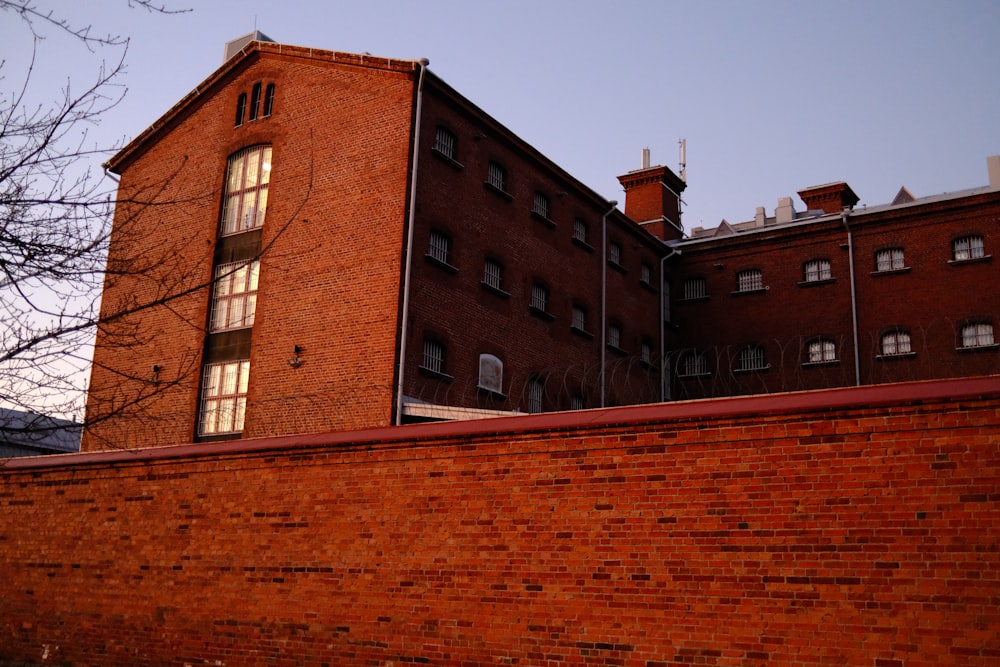 a brick building with windows and a red fence