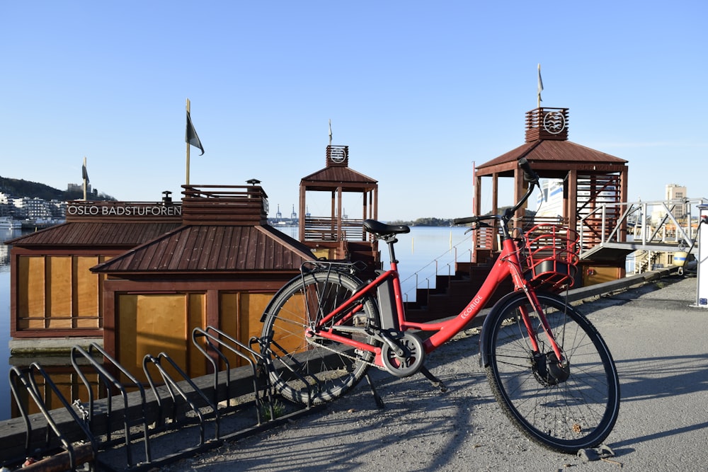 a red bicycle parked next to a pier