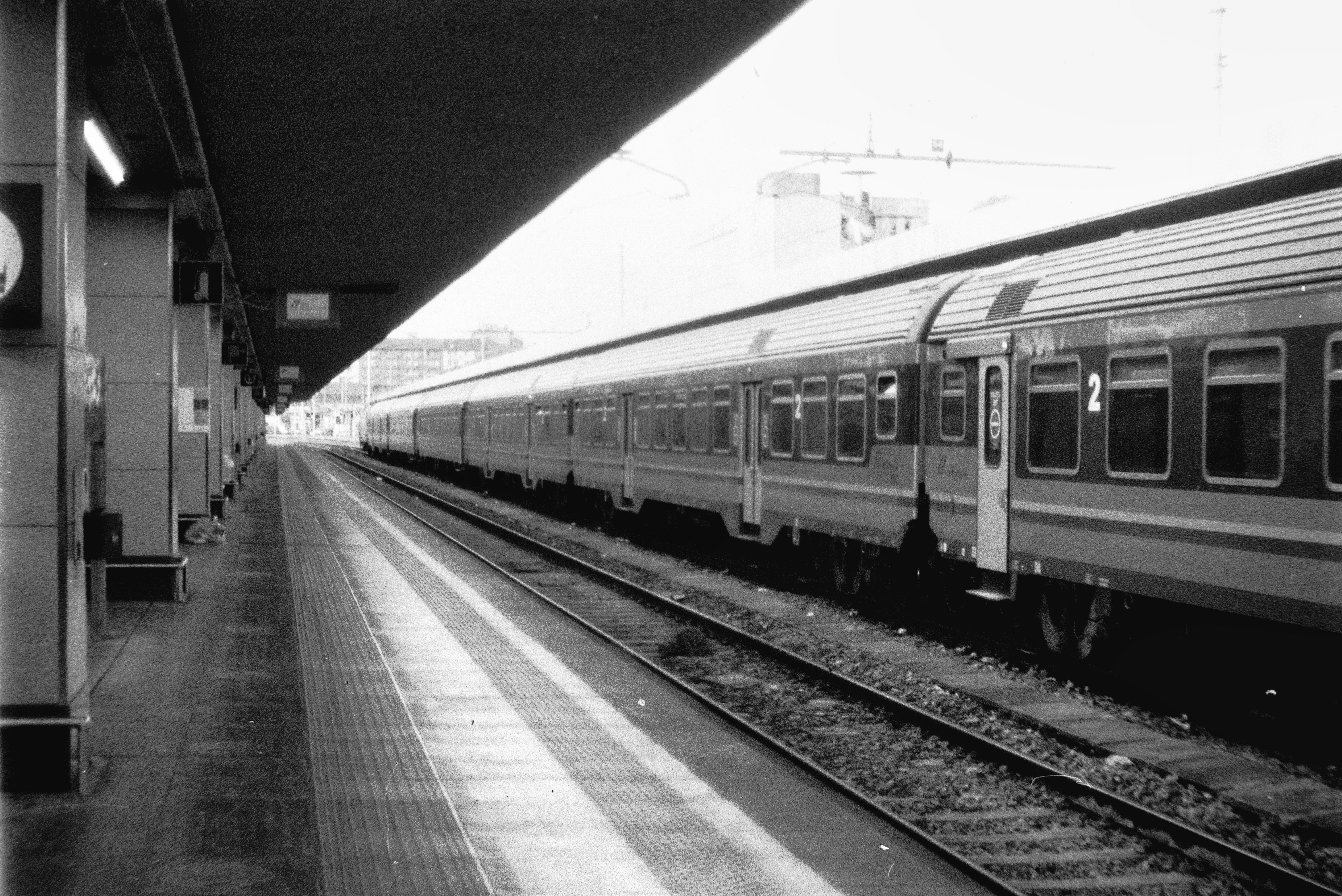 a black and white photo of a train at a train station, Just arrived