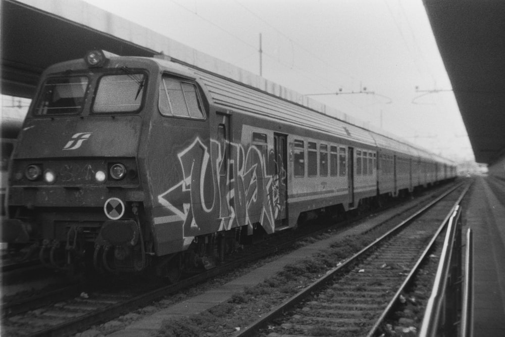 a black and white photo of a train with graffiti on it