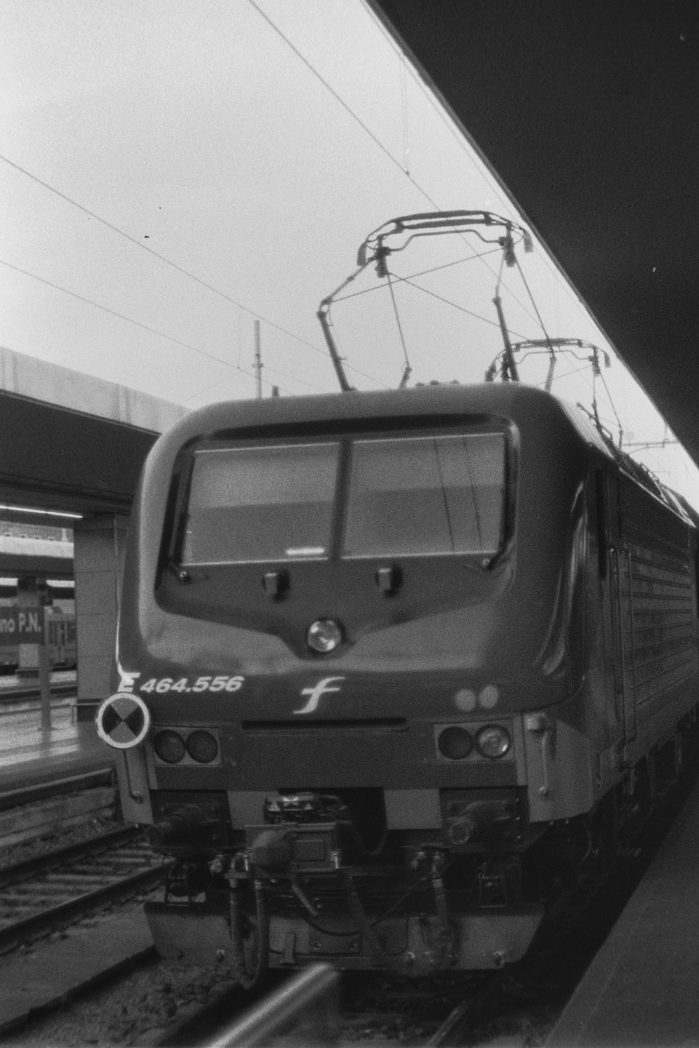 a black and white photo of a train pulling into a station